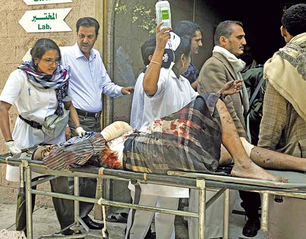 أطباء يحاولون إنقاذ أحد الجرحى يوم أمس 