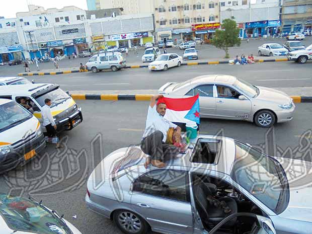 أحد المعتصمين يرفع علم الجنوب فوق سيارته بالساحة