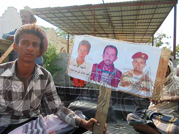 مواطن يرفع صور شهداء اللجان مواطن يرفع صور شهداء اللجان