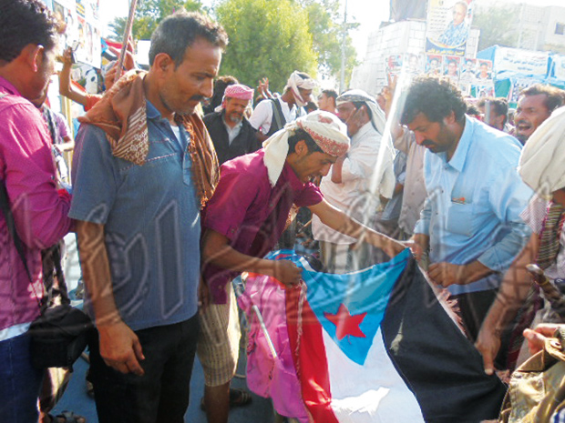 جنوبيون يضعون علم دولة الجنوب على جثمان الشهيد أمس