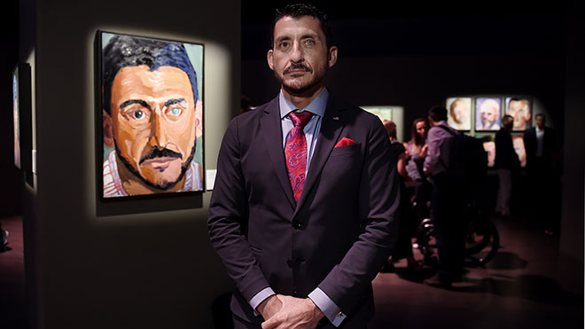 الرقيب من الدرجة الأولى مايكل رودريغيز يقف بجانب رسوماته