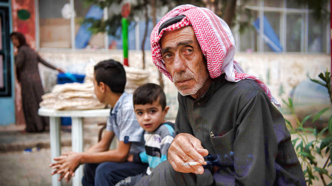 رجل سوري مهجّر يدخن داخل مدرسة تحولت إلى ملجأ للنازحين بسبب الحرب ، في بلدة الحسكة رجل سوري مهجّر يدخن داخل مدرسة تحولت إلى ملجأ للنازحين بسبب الحرب ، في بلدة الحسكة