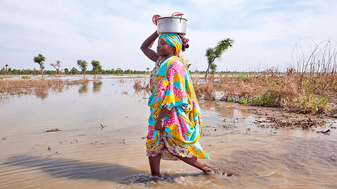 امرأة تمشي في مياه الفيضان في مخيم يوسف باتير للاجئين في مابان بجنوب السودان امرأة تمشي في مياه الفيضان في مخيم يوسف باتير للاجئين في مابان بجنوب السودان