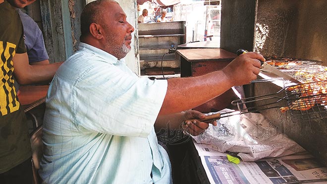أُسام بالو وهو يعد الدجاج أُسام بالو وهو يعد الدجاج