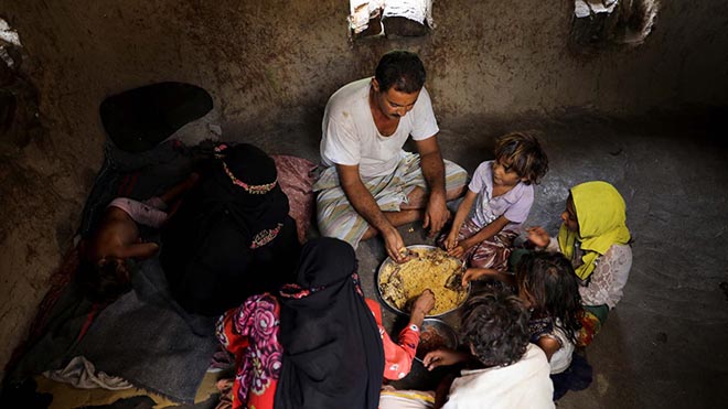 علي العمادي ، الذي يعمل حطابًا ، يتناول الغداء مع أسرته في منزلهم بقرية بمديرية خميس بنيساد بمحافظة المحويت - رويترز. علي العمادي ، الذي يعمل حطابًا ، يتناول الغداء مع أسرته في منزلهم بقرية بمديرية خميس بنيساد بمحافظة المحويت - رويترز.