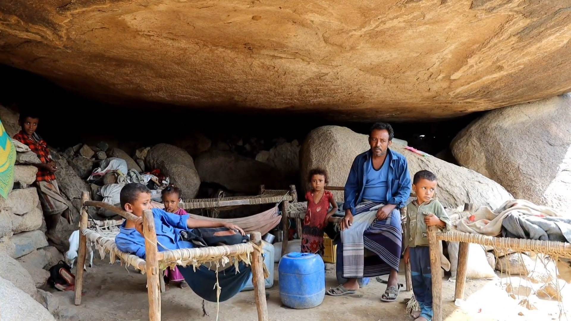 عائلة يمنية شردها الحوثيون تعيش تحت إحدى الصخور الضخمة